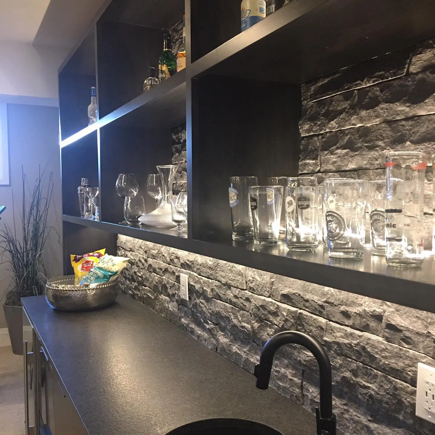 Stone bar with backsplash and lighting cabinetry by Heirlooms Custom Cabinetry