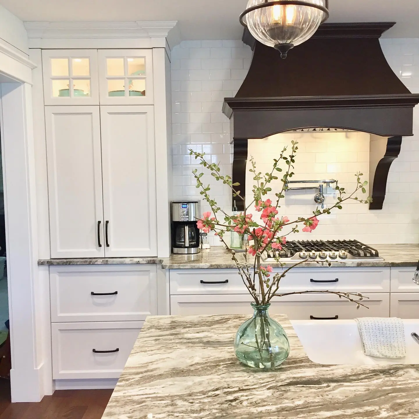 Painted kitchen with island and range hood cabinetry by Heirlooms Custom Cabinetry