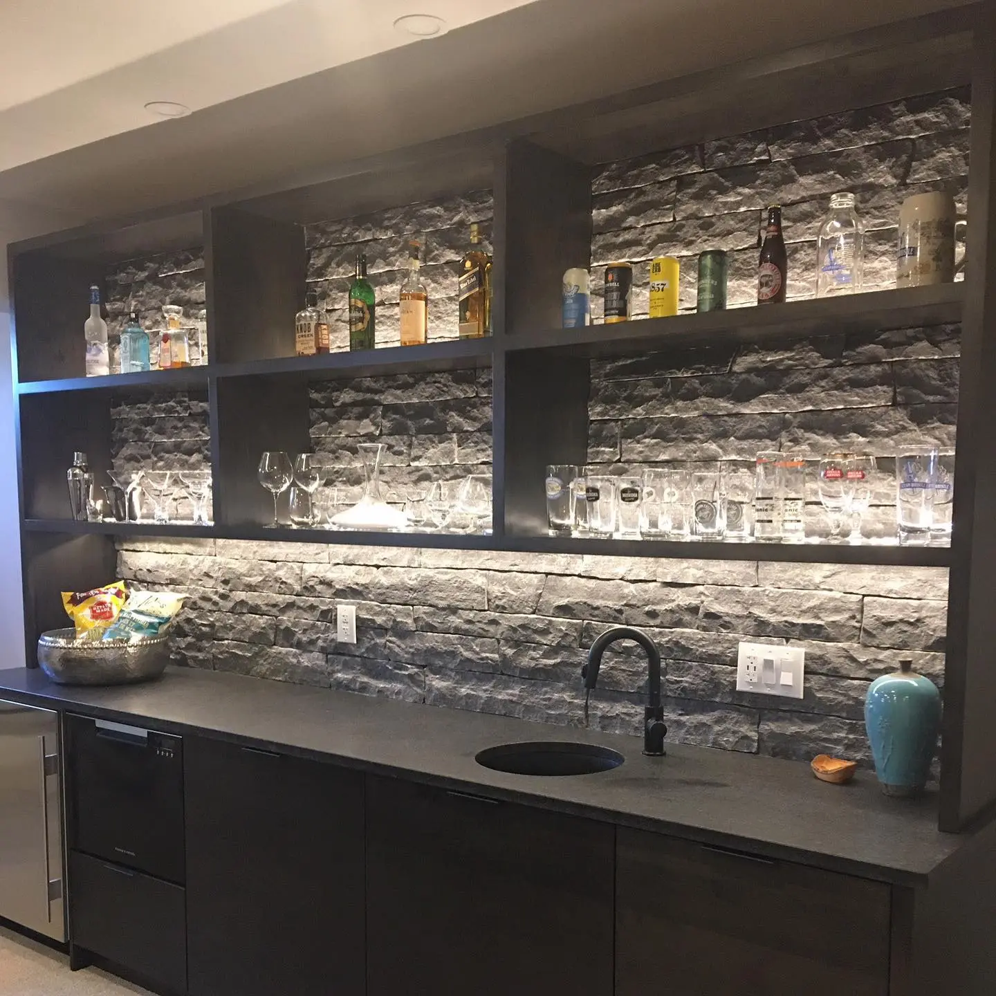 Stone bar with backsplash and lighting cabinetry by Heirlooms Custom Cabinetry