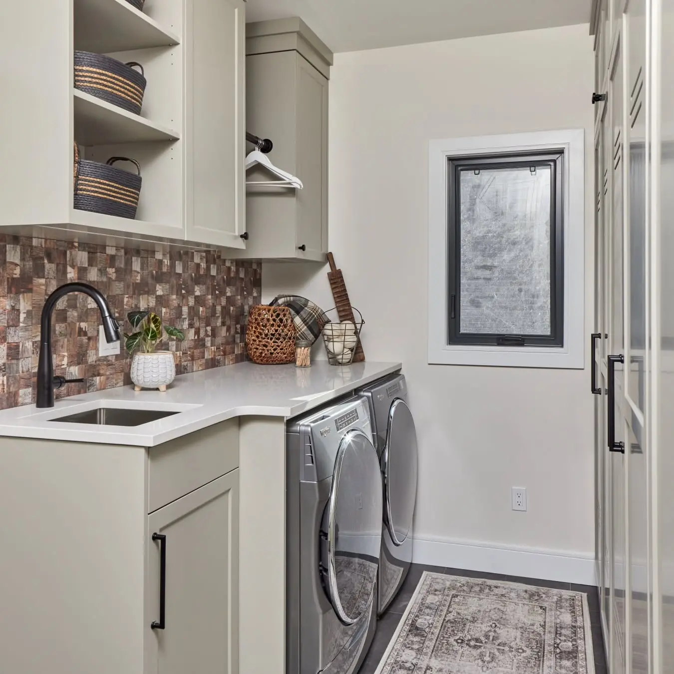 Laundry with storage and vented cabinetry by Heirlooms Custom Cabinetry